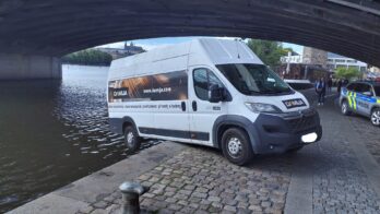 Emergency crews secure van suspended above riverbank